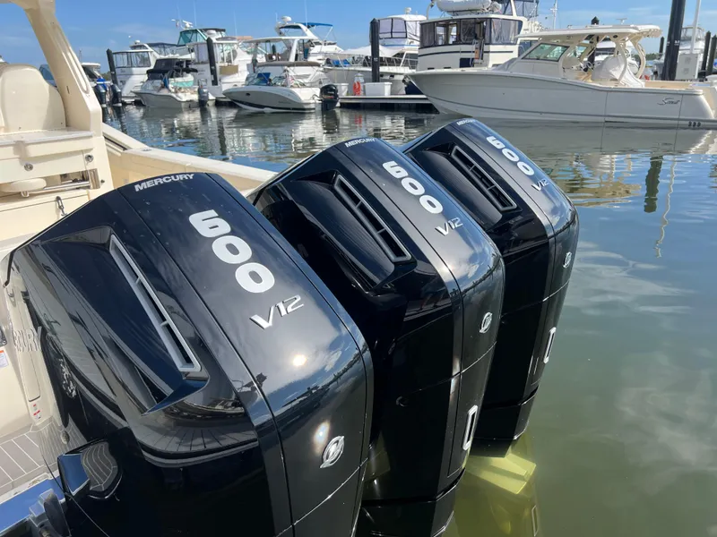 Slide: The Image of Triple Mercury 600 V12 engines on a 2025 Scout 425 LXF boat at a marina. - 34