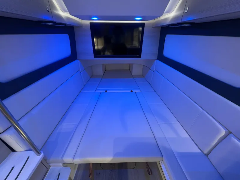 Slide: The Image of Luxurious interior of 2025 Scout 425 LXF boat with blue ambient lighting and TV. - 38