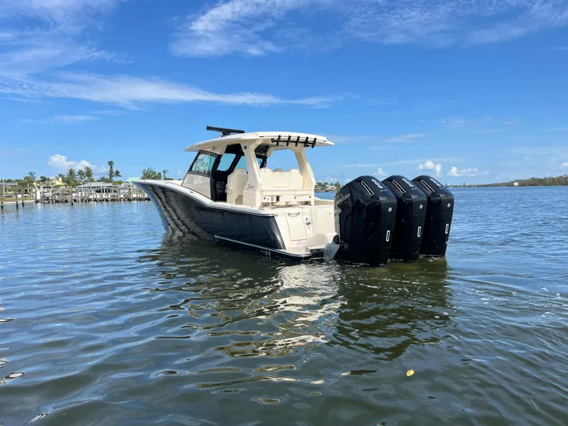 Slide: The Image of 2025 Scout 425 LXF boat with triple engines on calm water under blue sky. - 4