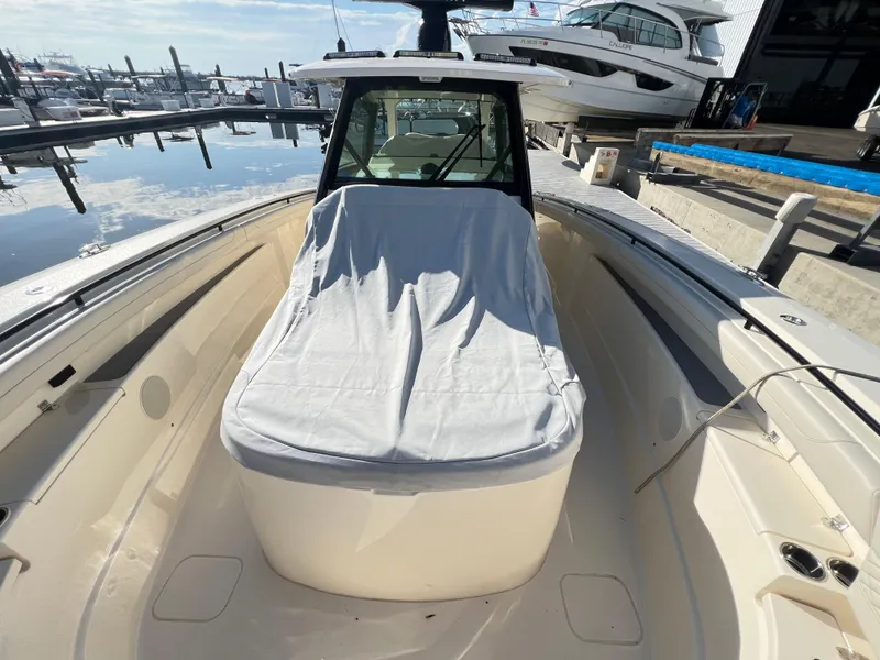 Slide: The Image of 2025 Scout 425 LXF boat docked at marina, covered seating area, sunny day. - 44