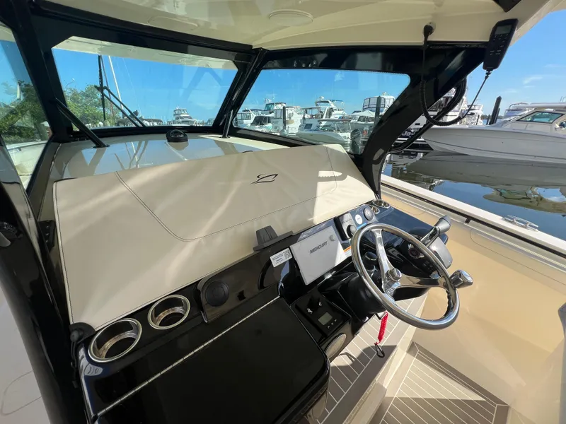 Slide: The Image of 2025 Scout 425 LXF boat helm with steering wheel and dashboard controls. - 45