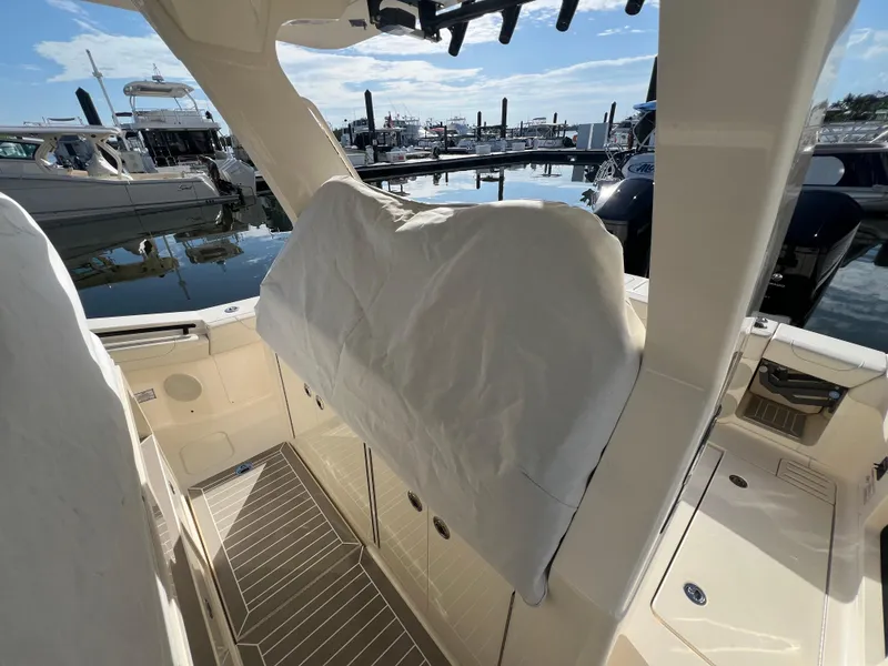 Slide: The Image of 2025 Scout 425 LXF boat interior at marina, showcasing sleek design and covered seating. - 47