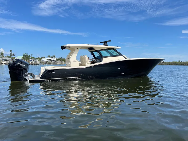 Slide: The Image of 2025 Scout 425 LXF boat on calm water under clear blue sky. - 8