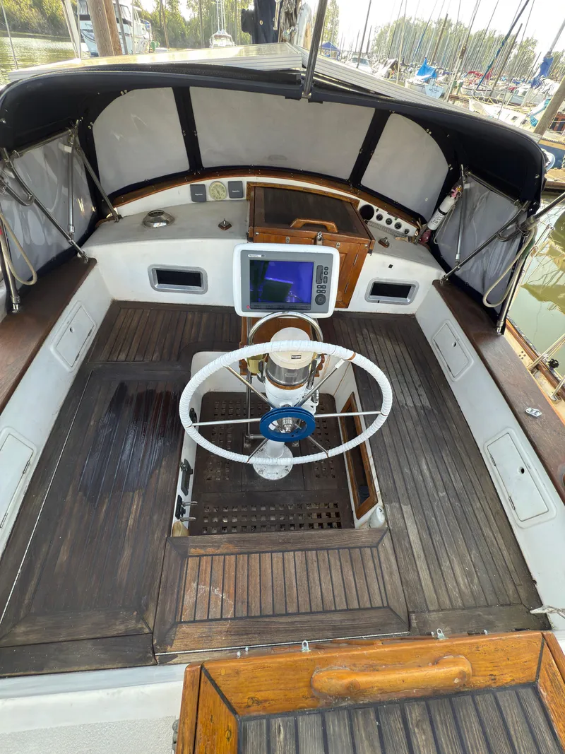 Slide: The Image of 1984 Spindrift Cutter sailboat cockpit with wooden deck and steering wheel. - 11