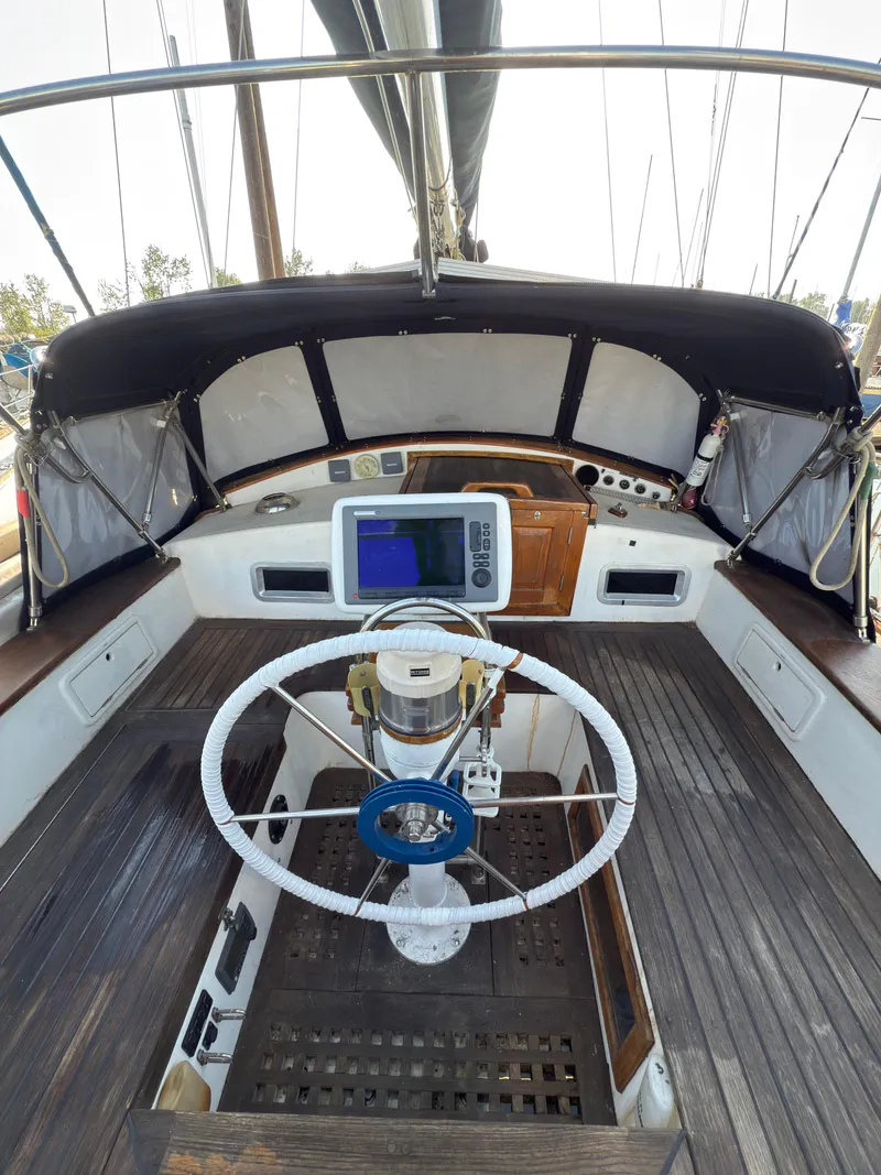 Slide: The Image of 1984 Spindrift Cutter sailboat cockpit with steering wheel and navigation equipment. - 12