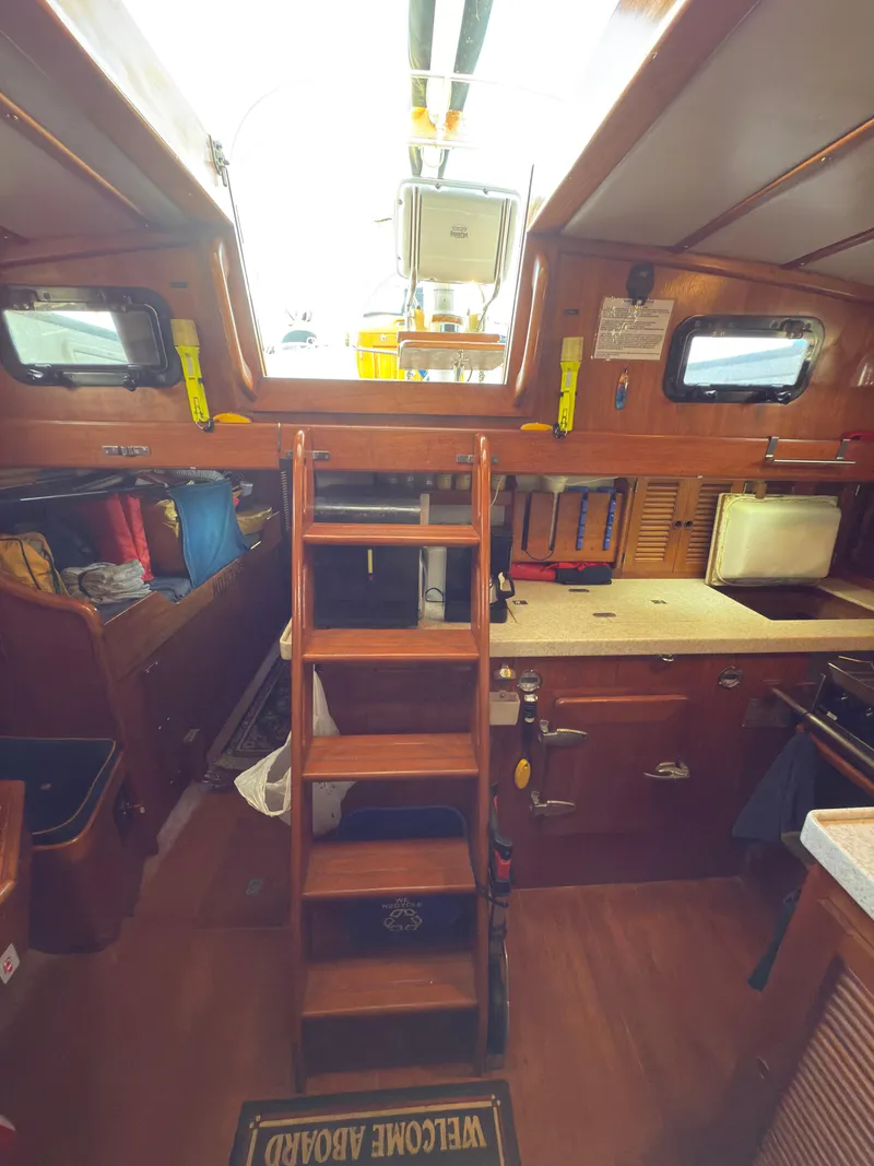 Slide: The Image of Interior of 1984 Spindrift Cutter sailboat with wooden stairs and compact kitchen area. - 14