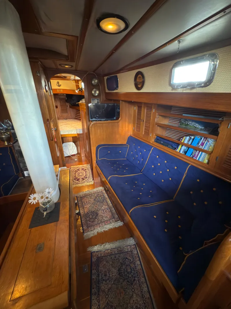 Slide: The Image of Interior of a 1984 Spindrift Cutter sailboat with cozy seating and wooden accents. - 17