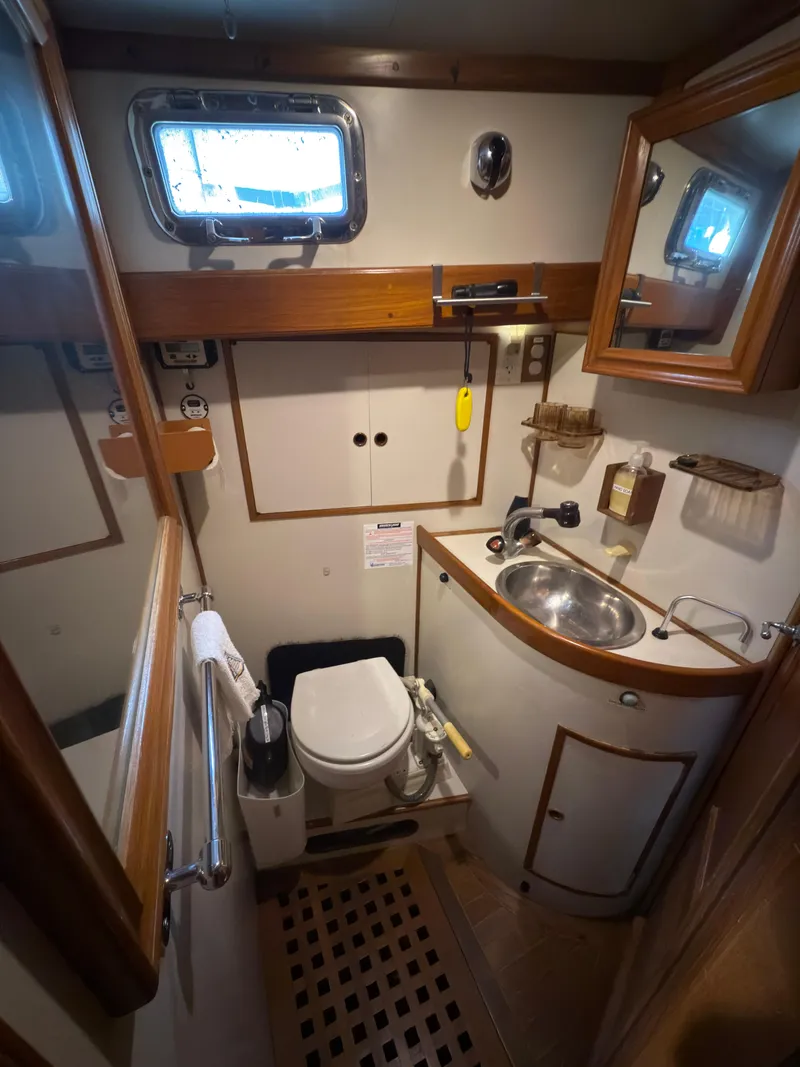 Slide: The Image of Compact bathroom in 1984 Spindrift Cutter yacht, featuring sink, toilet, and wooden accents. - 20