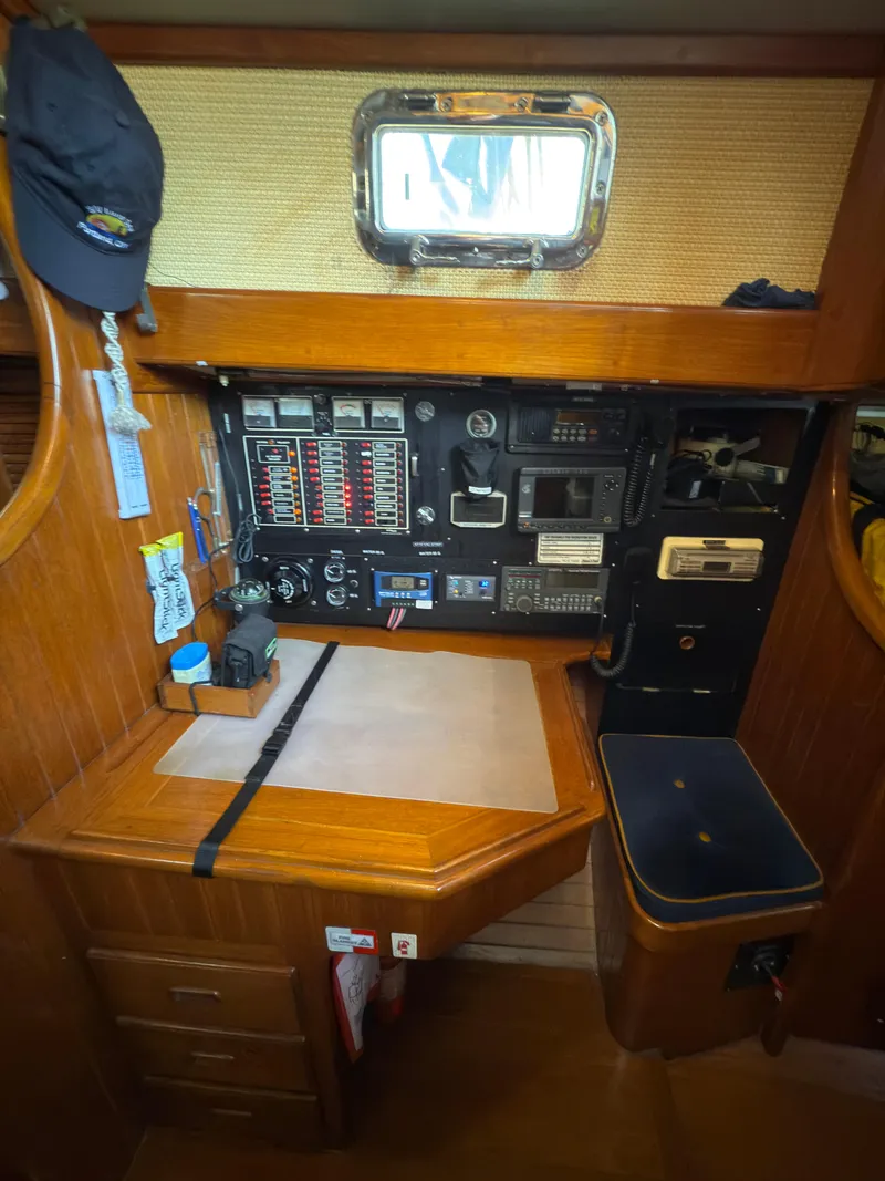 Slide: The Image of Navigation station inside a 1984 Spindrift Cutter sailboat, featuring control panels and a small desk. - 23