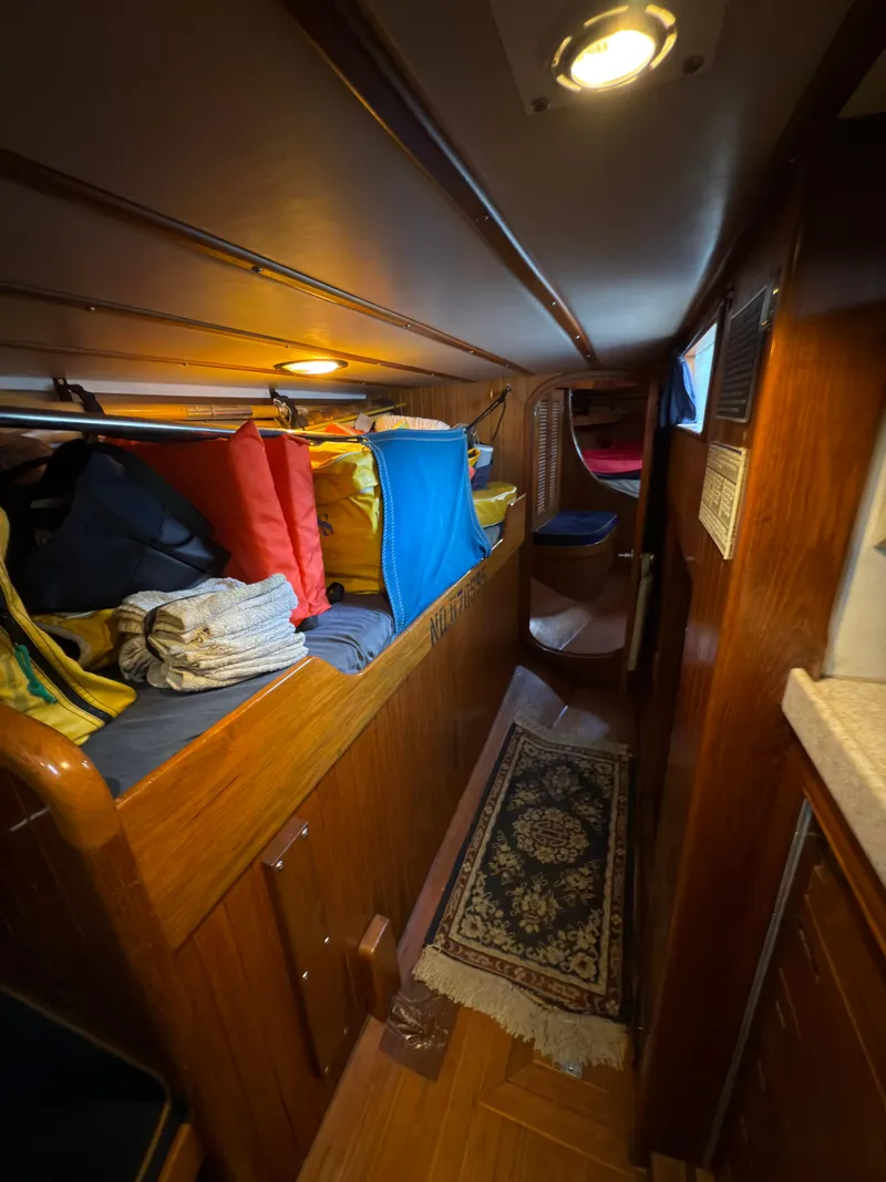 Slide: The Image of Narrow cabin interior of 1984 Spindrift Cutter with storage and cozy lighting. - 24
