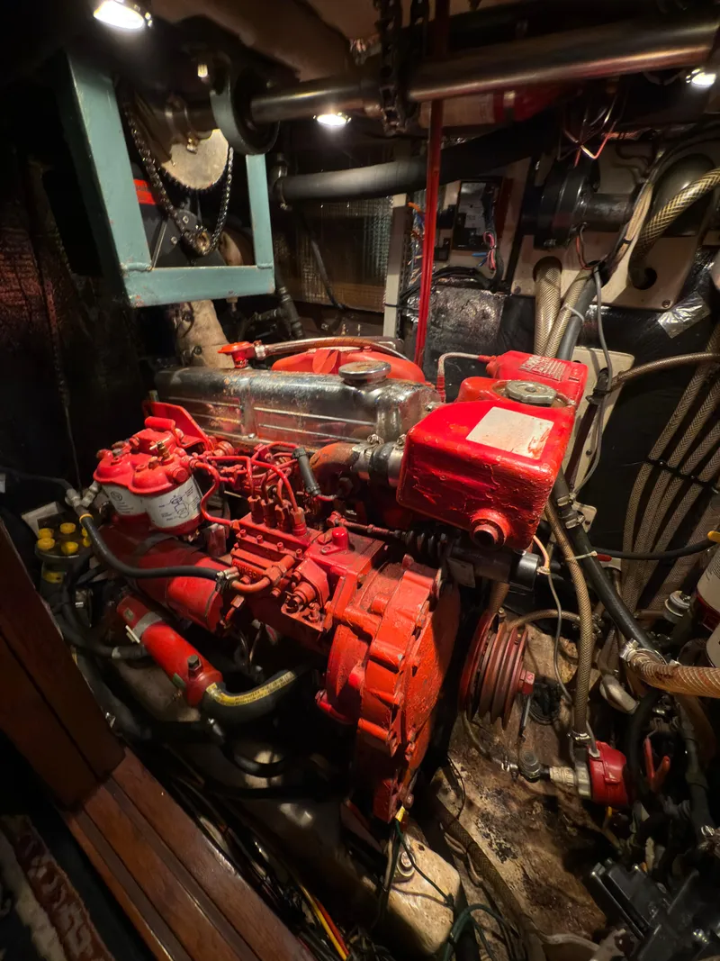 Slide: The Image of Engine room of a 1984 Spindrift Cutter sailboat, featuring a red marine engine. - 25
