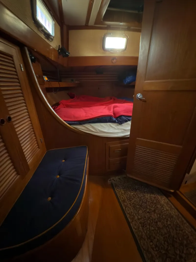 Slide: The Image of 1984 Spindrift Cutter cabin interior with wooden finish and cozy bedding. - 28