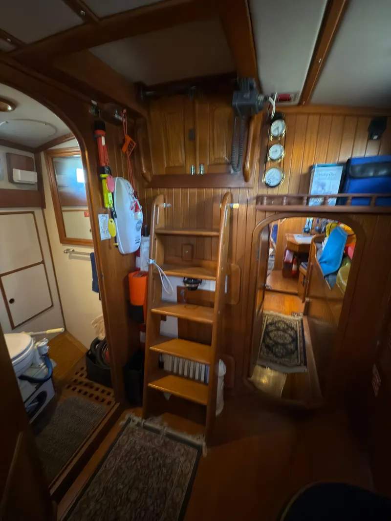 Slide: The Image of Interior of a 1984 Spindrift Cutter sailboat, featuring wooden paneling and nautical instruments. - 32