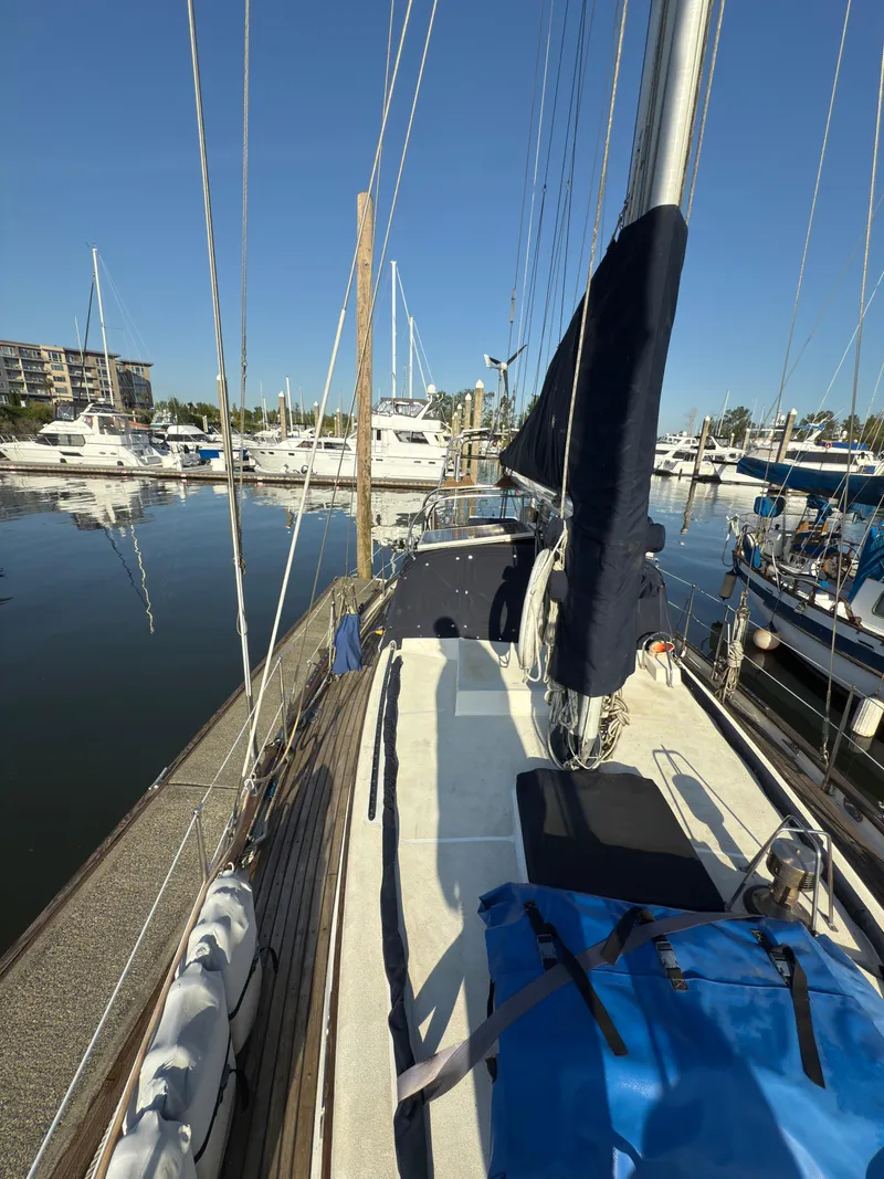Slide: The Image of 1984 Spindrift Cutter sailboat docked in a marina, surrounded by other boats. - 7