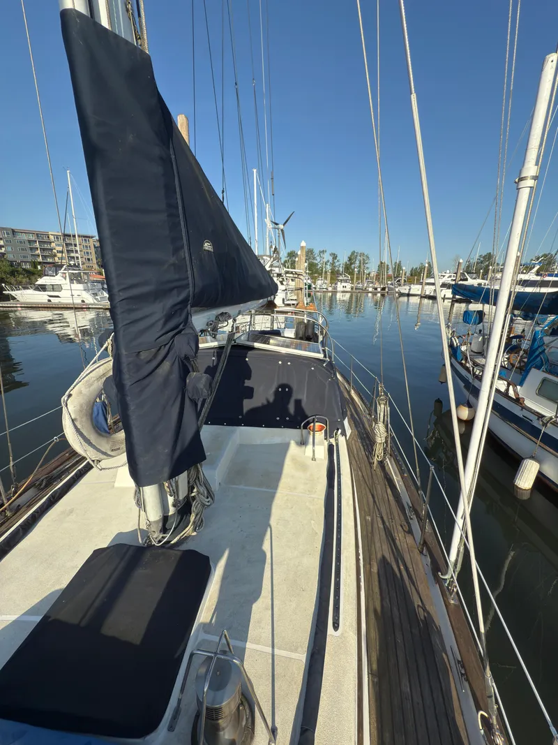 Slide: The Image of 1984 Spindrift Cutter sailboat docked in a marina, clear blue sky, calm waters. - 8