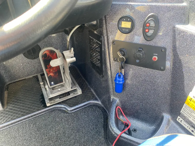 Slide: The Image of Control panel of a 2019 Triton 20 TRX Patriot boat with key and switches. - 12