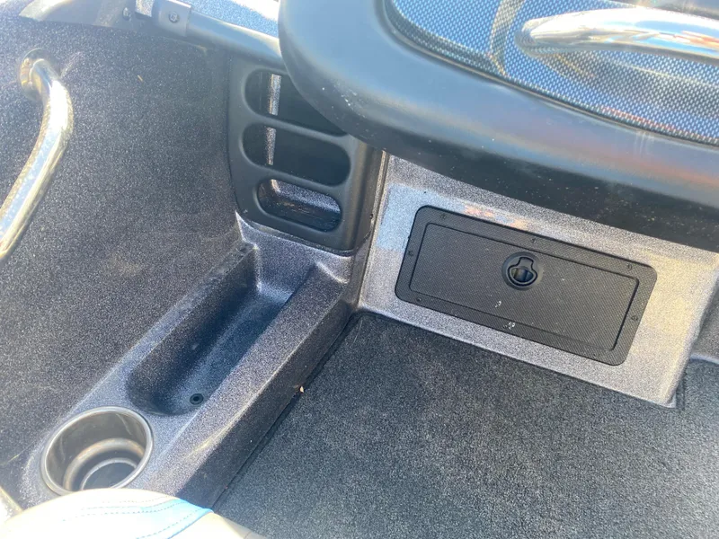 Slide: The Image of Interior of a 2019 Triton 20 TRX Patriot boat, featuring storage compartment and cup holder. - 17