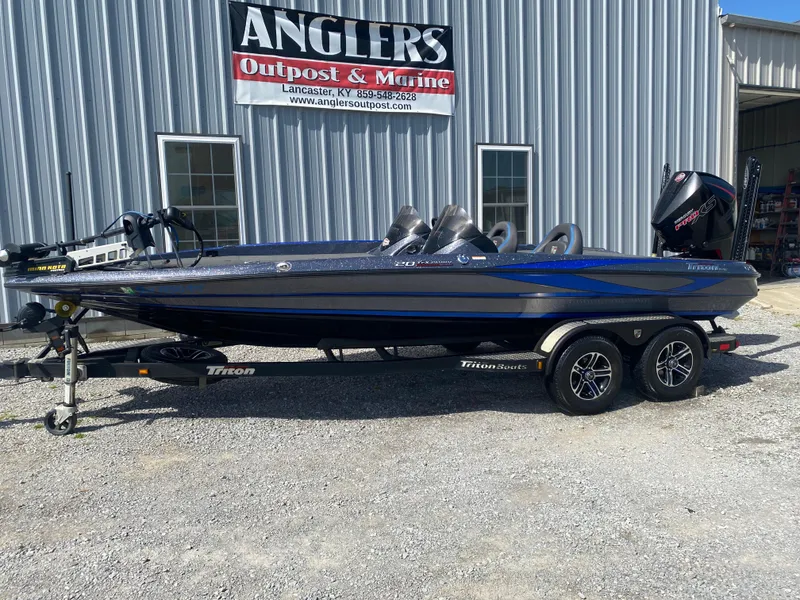 Slide: The Image of 2019 Triton 20 TRX Patriot boat on trailer outside Anglers Outpost & Marine. - 2