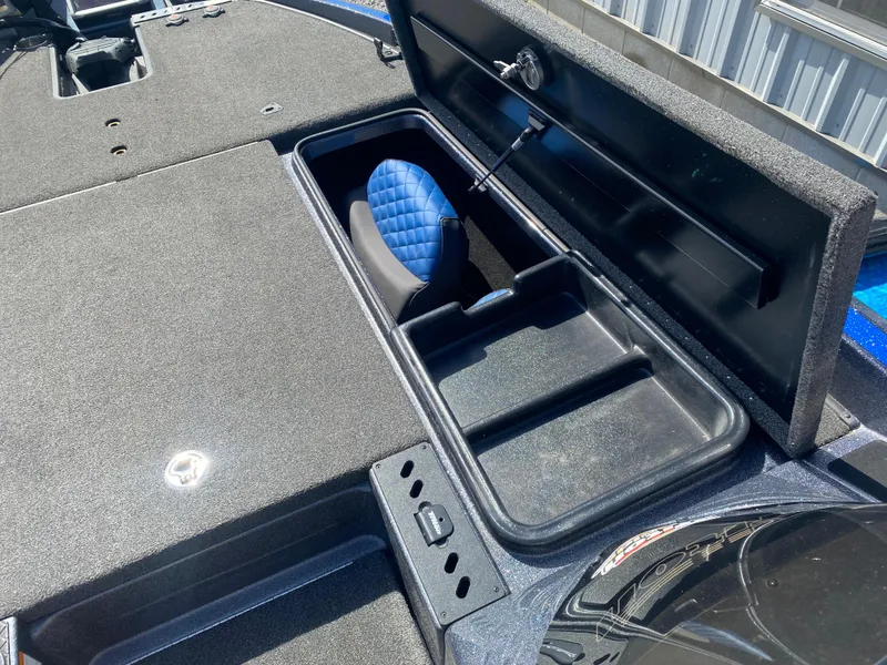 Slide: The Image of 2019 Triton 20 TRX Patriot boat storage compartment with blue seat cushion. - 20