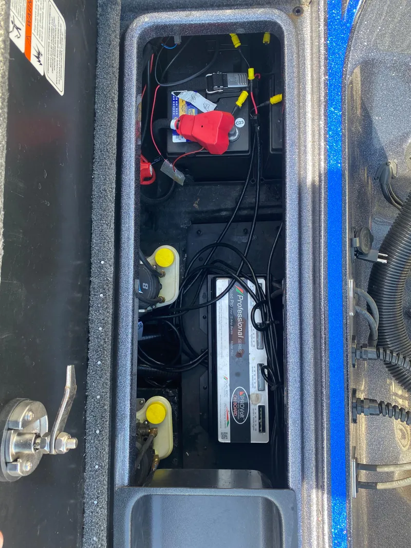 Slide: The Image of 2019 Triton 20 TRX Patriot boat battery compartment with wiring and components. - 22