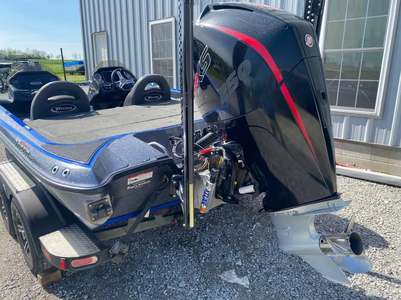 Slide: The Image of 2019 Triton 20 TRX Patriot boat with powerful outboard motor, parked on gravel. - 23