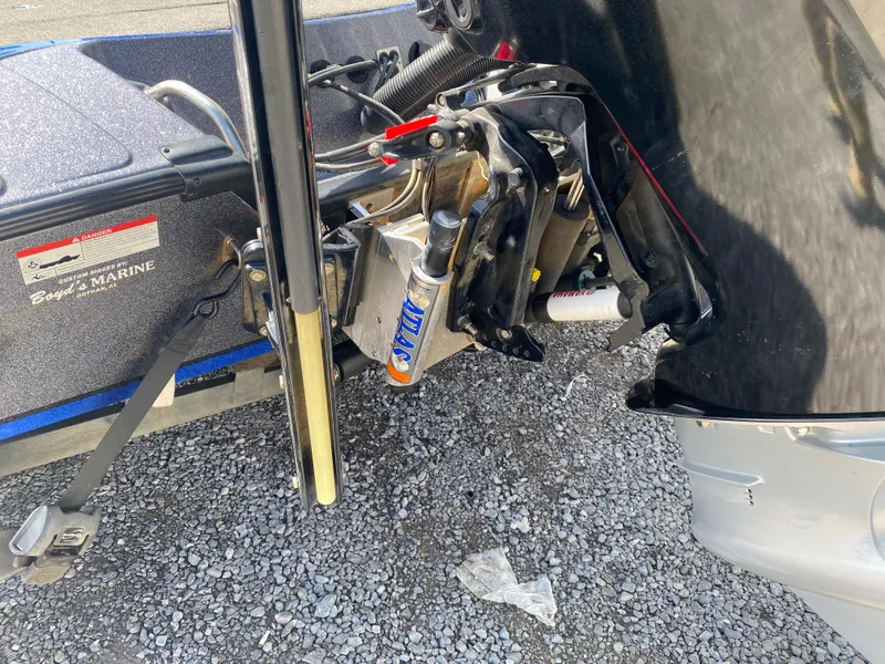 Slide: The Image of 2019 Triton 20 TRX Patriot boat engine and motor mount on gravel surface. - 24