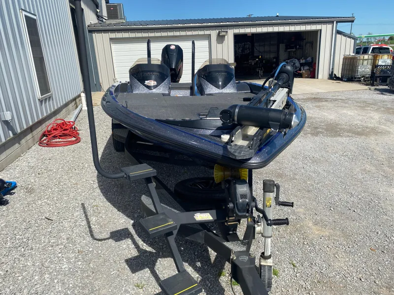 Slide: The Image of 2019 Triton 20 TRX Patriot boat parked on gravel near a garage. - 6