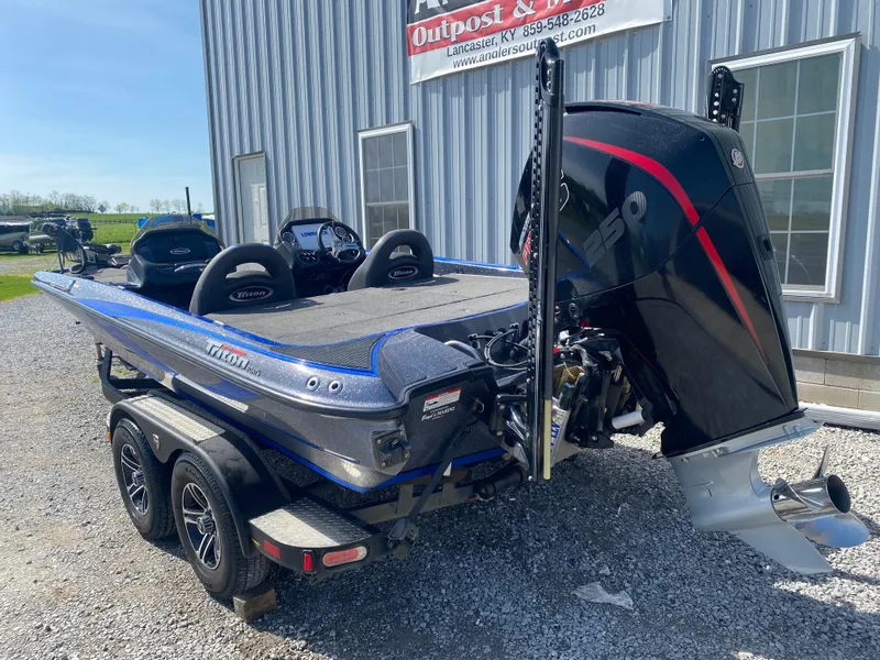 Slide: The Image of 2019 Triton 20 TRX Patriot boat with powerful engine, parked on gravel near a building. - 9