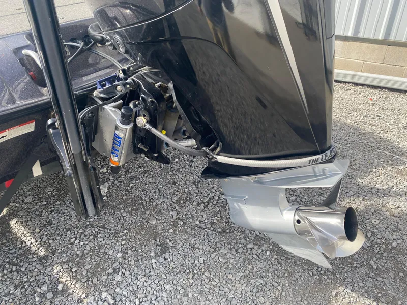 Slide: The Image of 2020 Triton 21 TrX boat motor and propeller on gravel surface. - 10