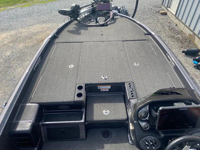 Slide: The Image of 2020 Triton 21 TrX boat interior with dashboard, storage compartments, and fishing equipment. - 14