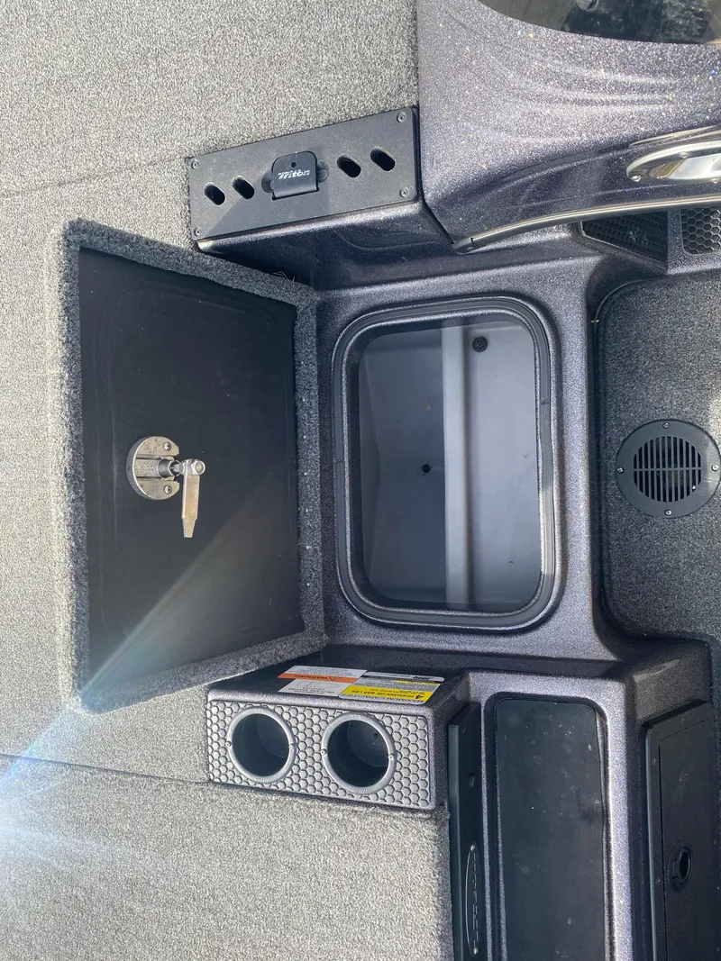 Slide: The Image of 2020 Triton 21 TrX boat interior storage compartments and cup holders. - 21