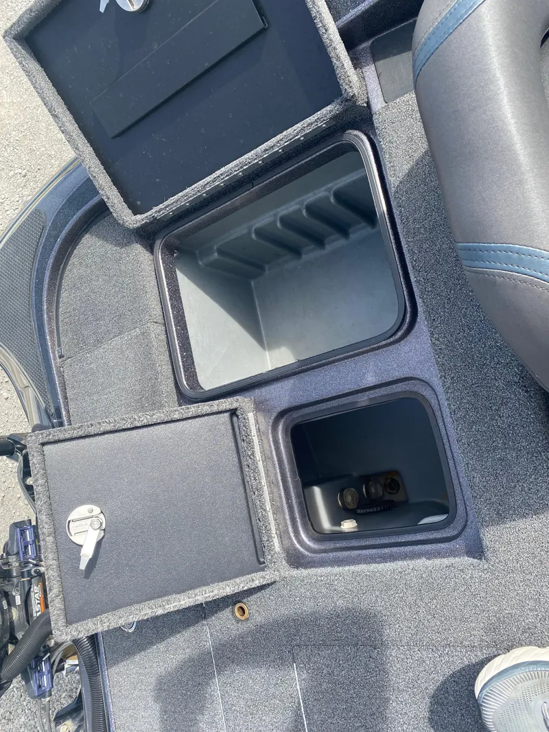 Slide: The Image of 2020 Triton 21 TrX boat storage compartments with open lids, showcasing interior space. - 24