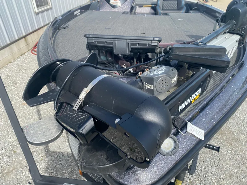 Slide: The Image of 2020 Triton 21 TrX boat with Minn Kota trolling motor on gravel surface. - 6