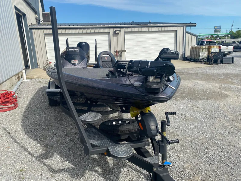 Slide: The Image of 2020 Triton 21 TrX bass boat on trailer in outdoor storage area. - 7