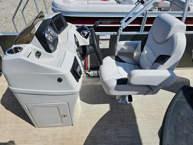Slide: The Image of 2023 SunCatcher Select 320 F boat helm with modern controls and comfortable captain's chair. - 13