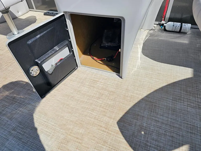 Slide: The Image of Open storage compartment on 2023 SunCatcher Select 320 F boat, showing interior wiring and fire extinguisher. - 14