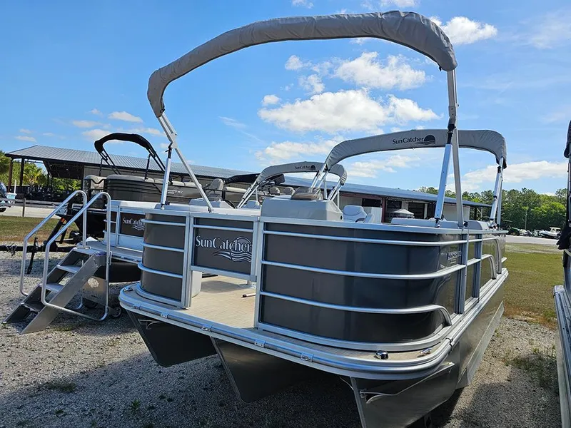 Slide: The Image of 2023 SunCatcher Select 320 F pontoon boat with canopy, parked outdoors under blue sky. - 3