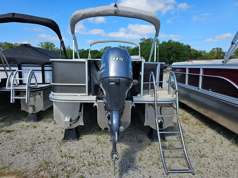 Slide: The Image of 2023 SunCatcher Select 320 F pontoon boat with outboard motor and ladder, parked on gravel. - 6