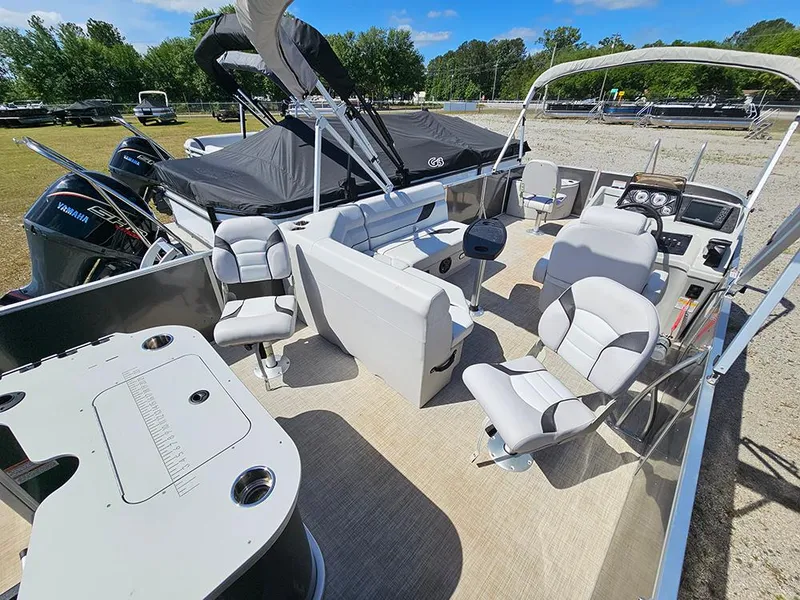 Slide: The Image of 2023 SunCatcher Select 320 F pontoon boat interior with seating and console, parked outdoors. - 7
