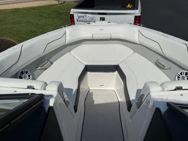 Slide: The Image of 2025 Regal LS2 boat interior with white seating and speakers, parked near a truck. - 13