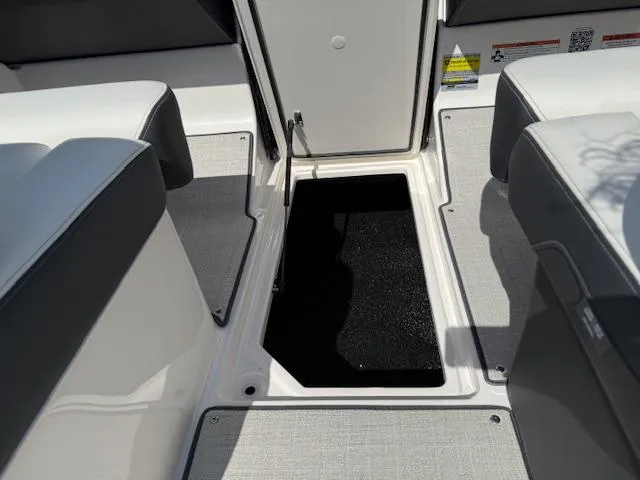 Slide: The Image of 2025 Regal LS2 boat interior storage compartment with open hatch and seating. - 32