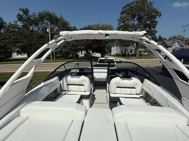 Slide: The Image of 2025 Regal LS2 boat with white interior and sleek design, parked outdoors. - 4