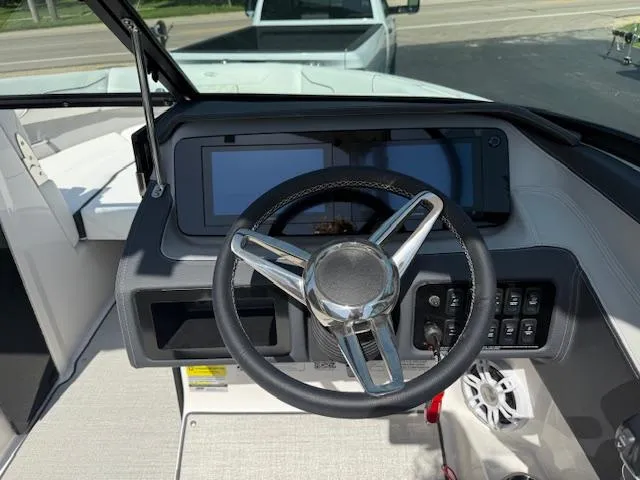 Slide: The Image of Steering wheel and dashboard of 2025 Regal LS2 boat, featuring modern controls and display. - 7