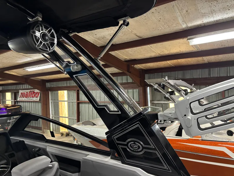 Slide: The Image of 2023 Cobalt R4 Surf boat interior with sleek design and advanced audio system in a garage. - 19