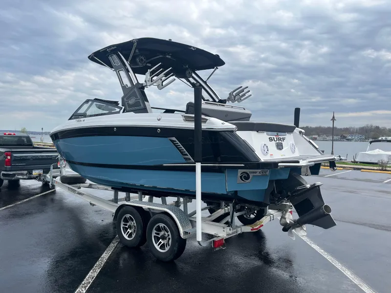 Slide: The Image of 2023 Cobalt R4 Surf boat on trailer in parking lot, under cloudy sky. - 3
