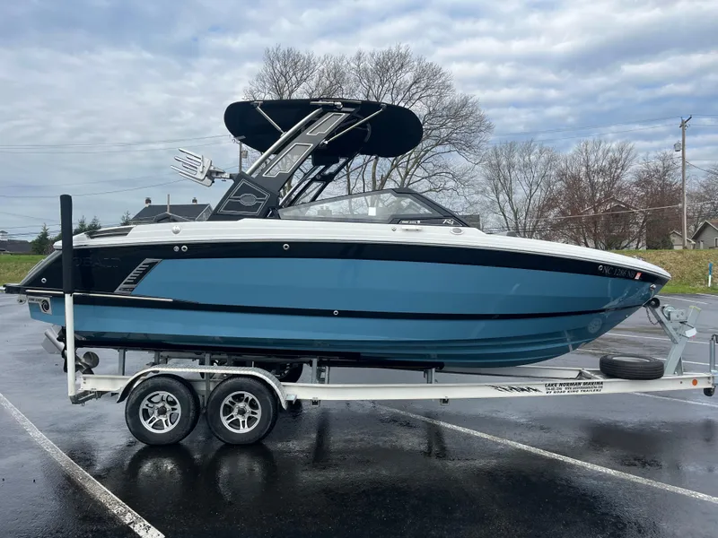 Slide: The Image of 2023 Cobalt R4 Surf boat on trailer, blue hull, parked outdoors. - 8
