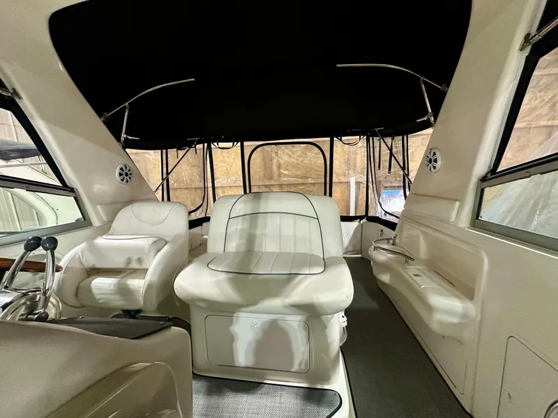 Slide: The Image of 1999 Sea Ray 310 Sundancer interior with white seating and black canopy. - 14