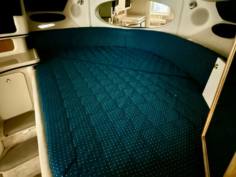 Slide: The Image of 1999 Sea Ray 310 Sundancer cabin with blue quilted bedding and modern interior design. - 17