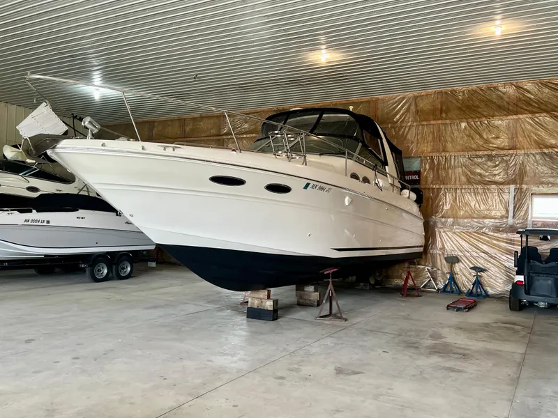 Slide: The Image of 1999 Sea Ray 310 Sundancer boat stored indoors on blocks in a garage. - 2