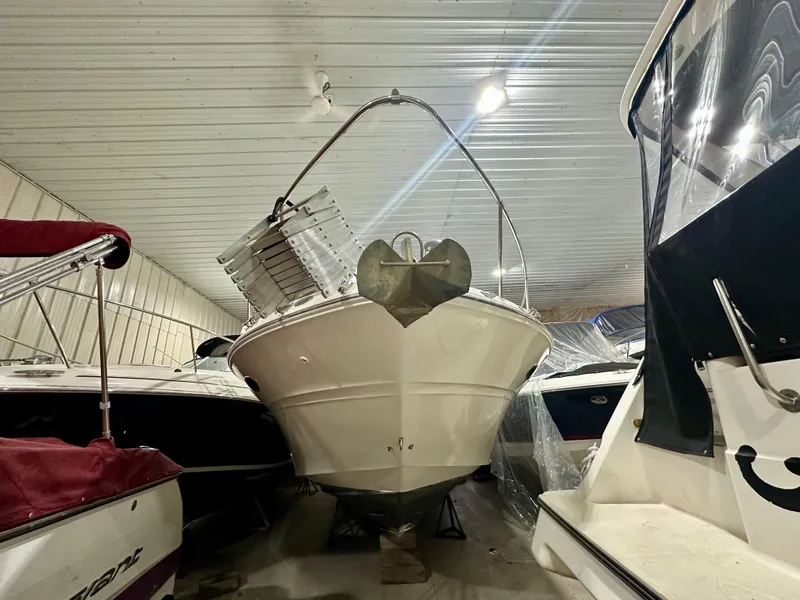 Slide: The Image of 1999 Sea Ray 310 Sundancer boat stored indoors, surrounded by other vessels. - 3